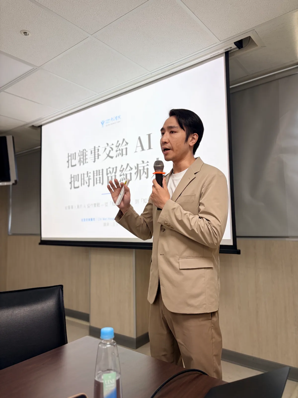 Dawson Wang 在佳里奇美醫院投影幕前講解如何把日常工作交給 AI 處理