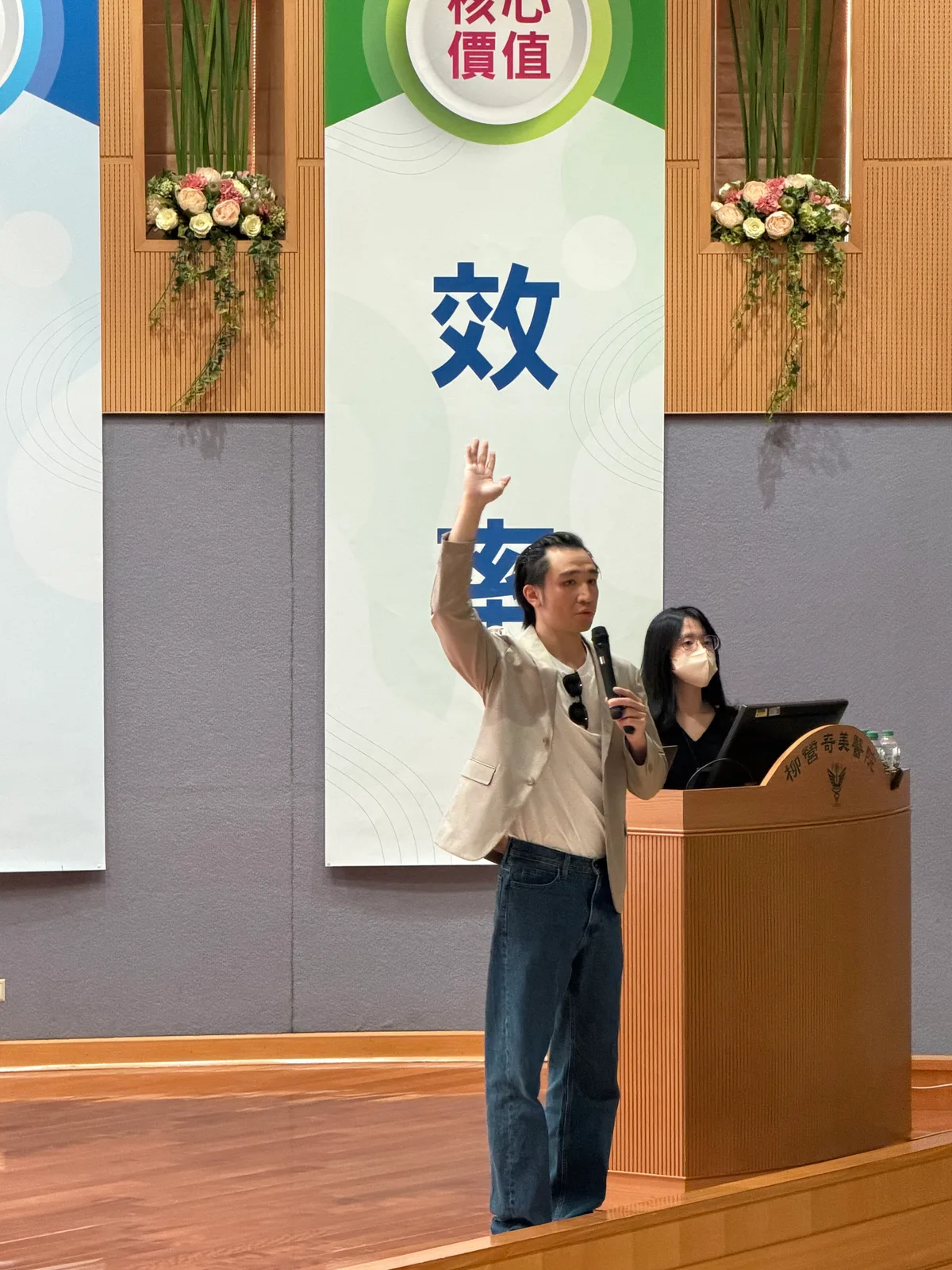 Dawson Wang 在柳營奇美醫院講台前舉手說明課程重點，助教在後方操作