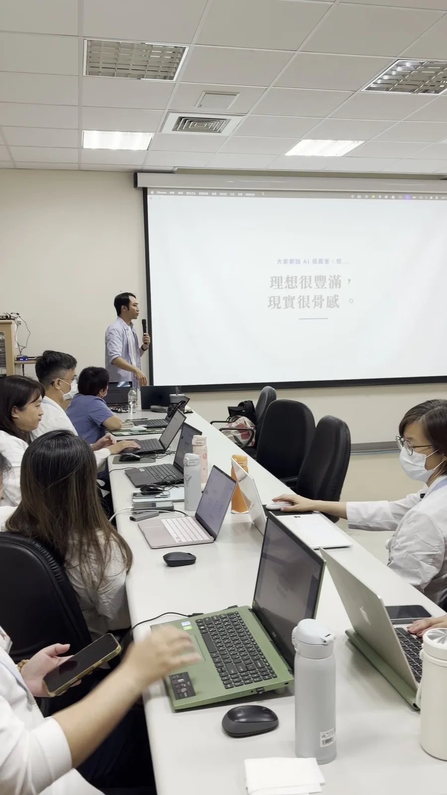 柳營奇美醫院學員使用筆電實作，Dawson Wang 在投影幕前說明 AI 工作落差